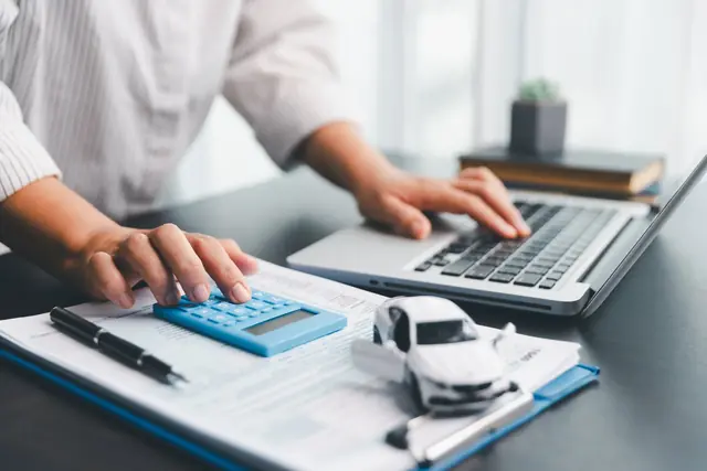 Financial plan being prepared with a calculator and laptop