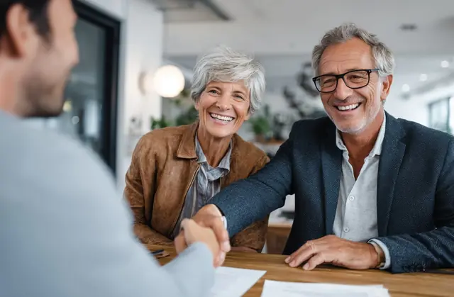Retired couple shaking hands with their advisor