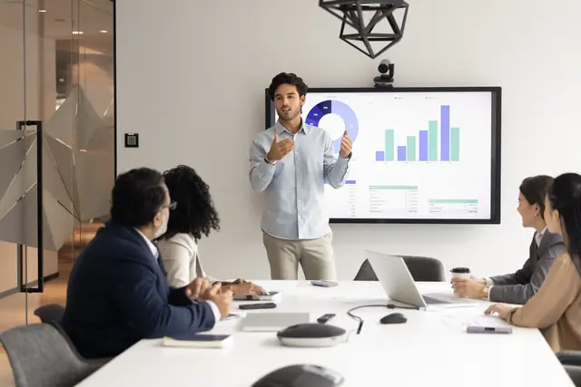 Team meeting with charts on a display